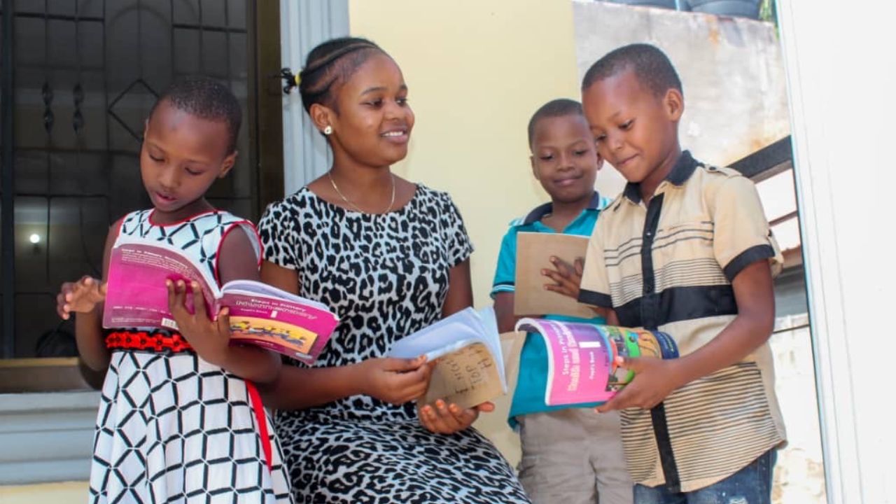 Reading with children at Real Life Orphanage, Buza