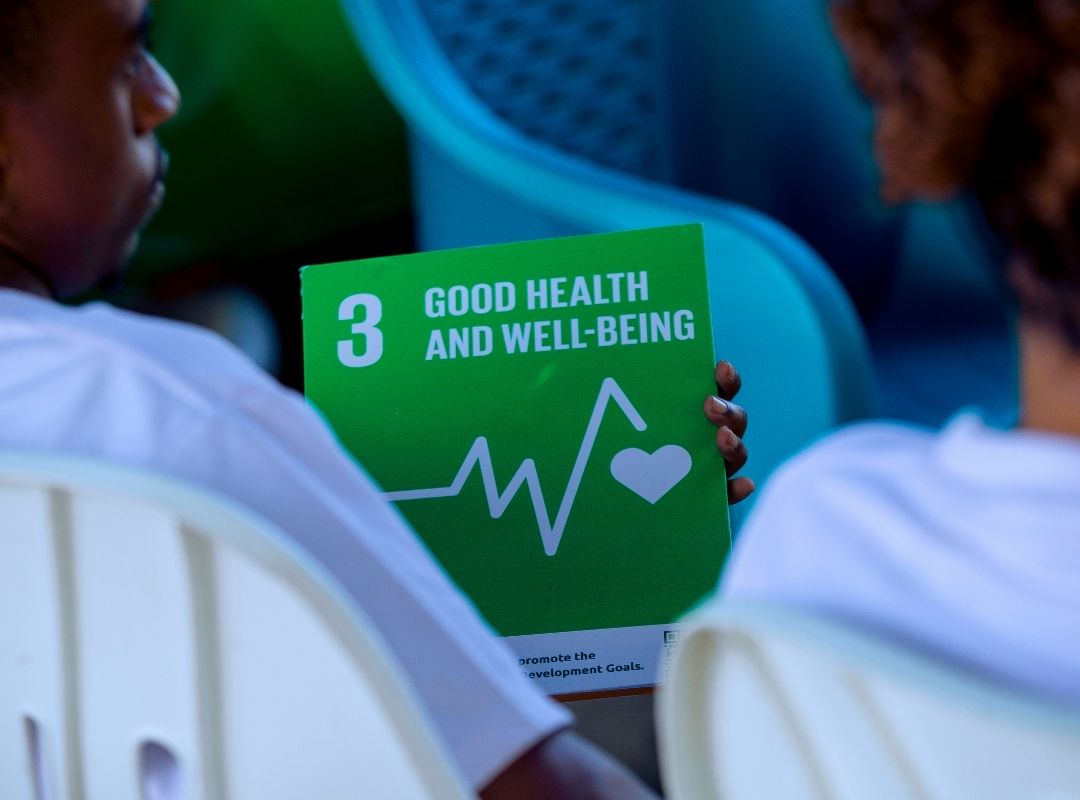 Children holding SDG 3 card during Bagamoyo outreach