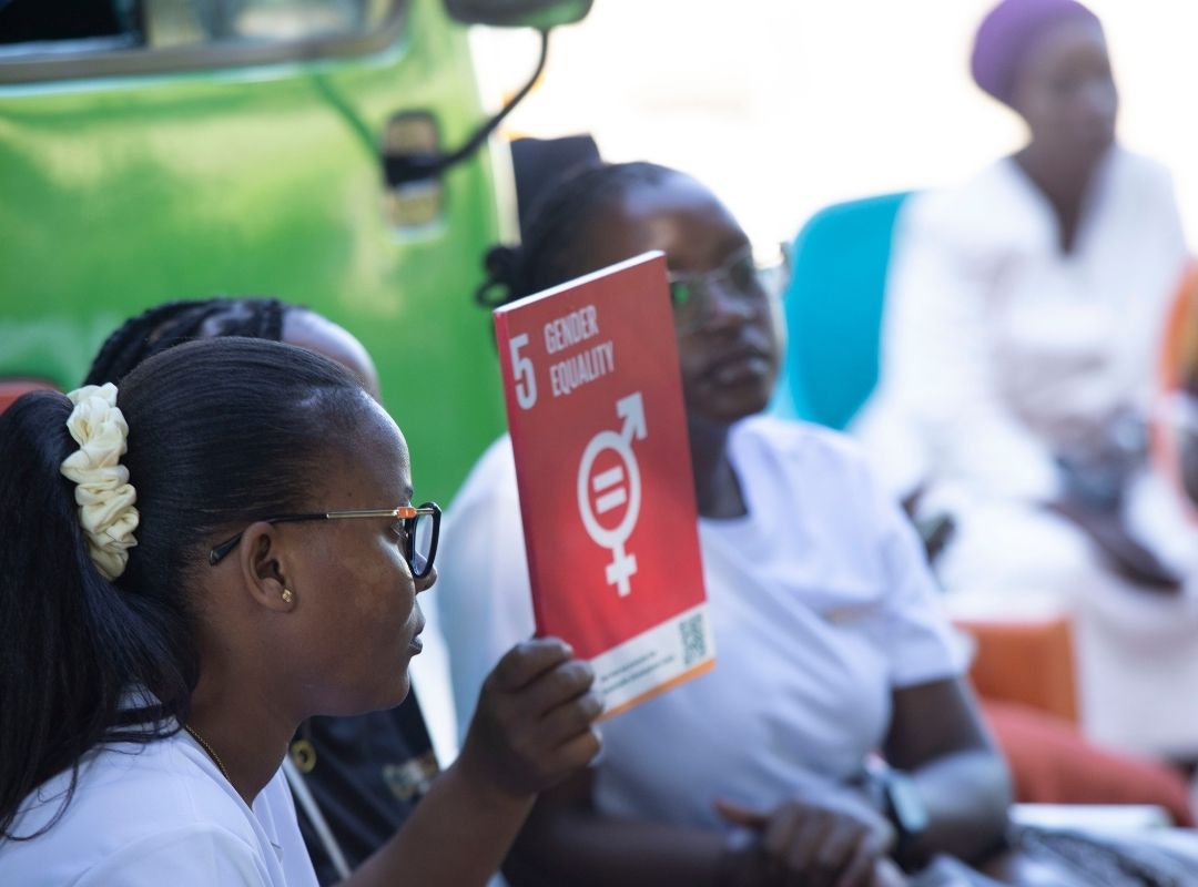 Children holding SDG 5 card during Bagamoyo outreach