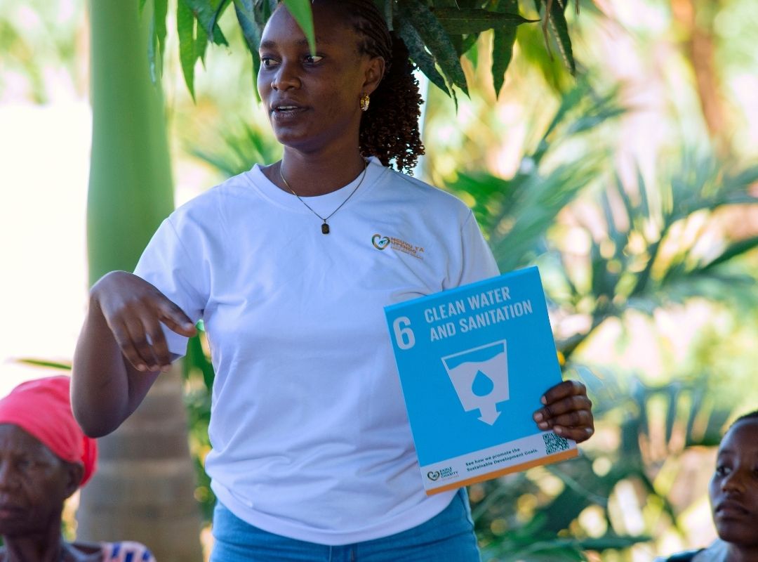Celina Didas holding SDG 6 card during Bagamoyo outreach